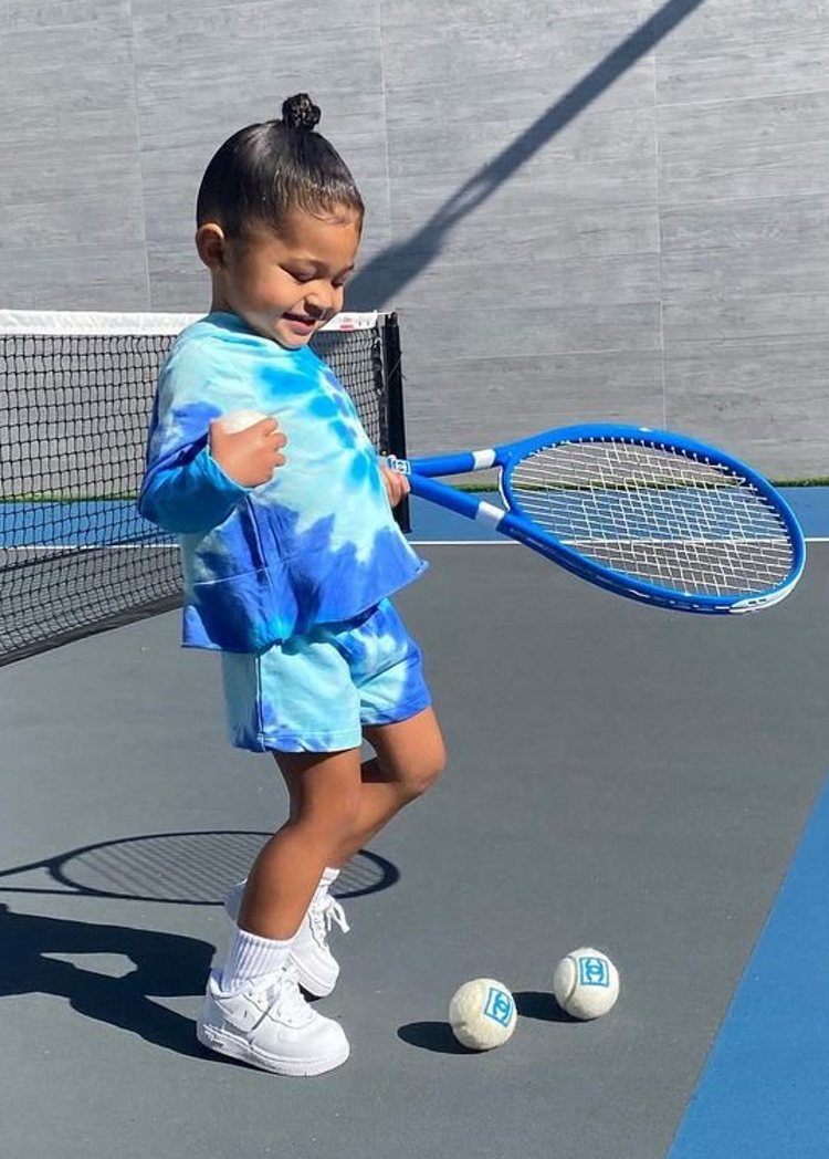 Stormi Webster con un look tie dye en azul y blanco jugando al tenis