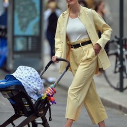 Karlie Kloss con un conjunto amarillo pastel paseando a su hijo por Nueva York