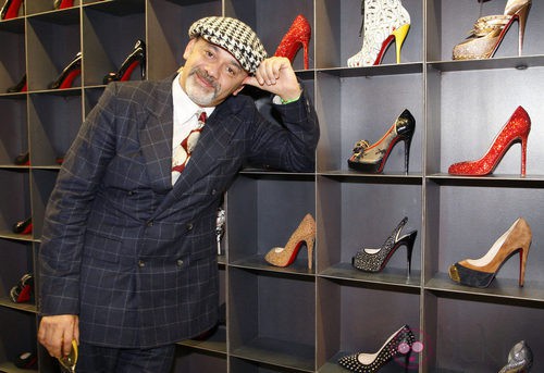 Christian Louboutin posa con varios modelos de sus zapatos