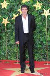 Antonio Banderas con traje negro desabrochado y camisa blanca informal
