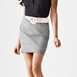Amy Winehouse con falda gris y polo azul marino para Fred Perry
