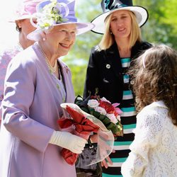 La Reina Isabel II con un conjunto violeta y sombrero en el mismo color