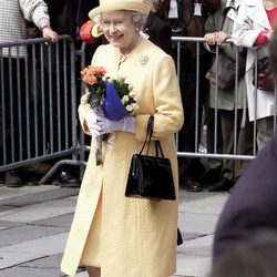 La Reina Isabel II de Inglaterra con un vestido primaveral en color amarillo de Angela Kelly