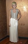 Miley Cyrus con una falda larga color crema y top con tachuelas y cremallera