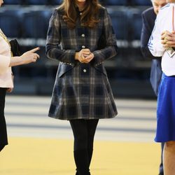 Kate Middleton con un abrigo de cuadros y botas altas 