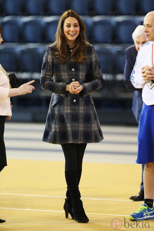 Kate Middleton con un abrigo de cuadros y botas altas 