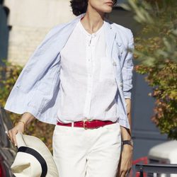 Inès de la Fressange posando para Uniqlo con un conjunto de blusa y pantalón blanco
