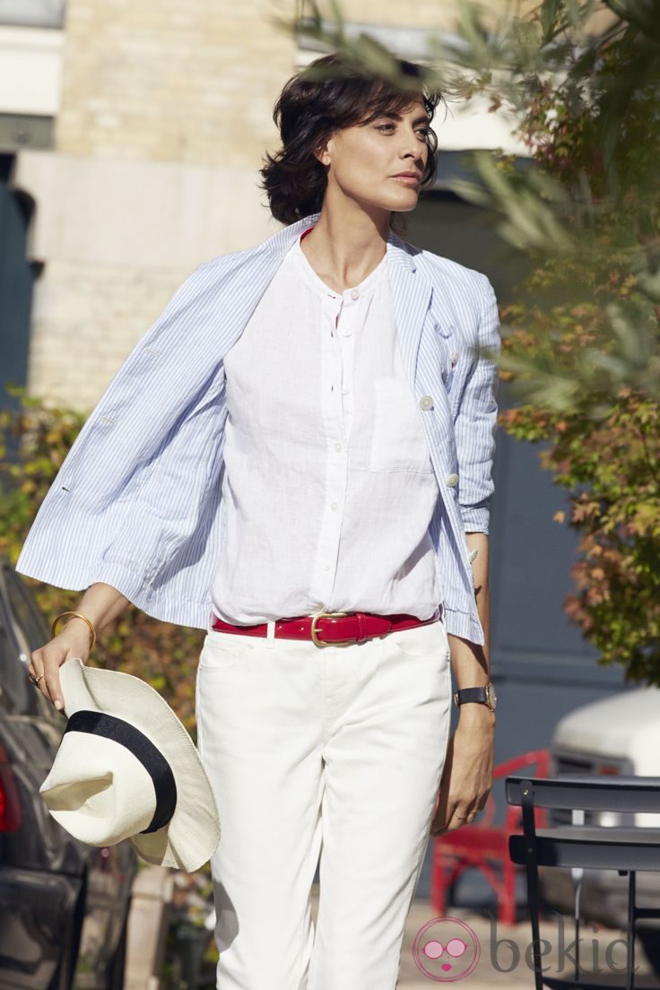 Inès de la Fressange posando para Uniqlo con un conjunto de blusa y pantalón blanco
