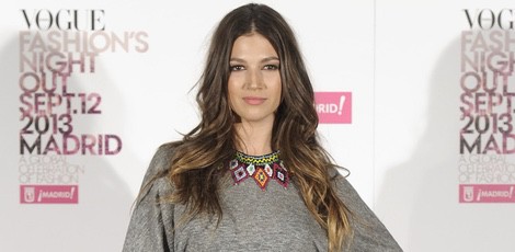 Úrsula Corberó con falda de cuero naranja y blusa gris con abalorios