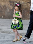 Suri Cruise con vestido de flores y zapatos de tacón dorados