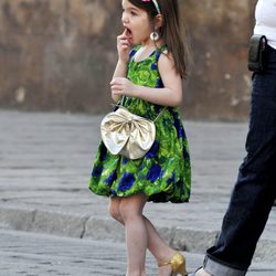 Suri Cruise con vestido de flores y zapatos de tacón dorados