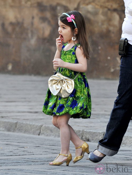 Suri Cruise con vestido de flores y zapatos de tacón dorados