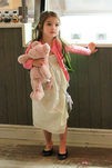 Suri Cruise con vestido blanco y chaqueta rosa
