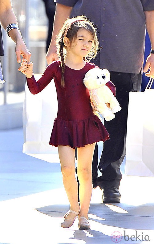 Suri Cruise con traje de ballet y un peluche