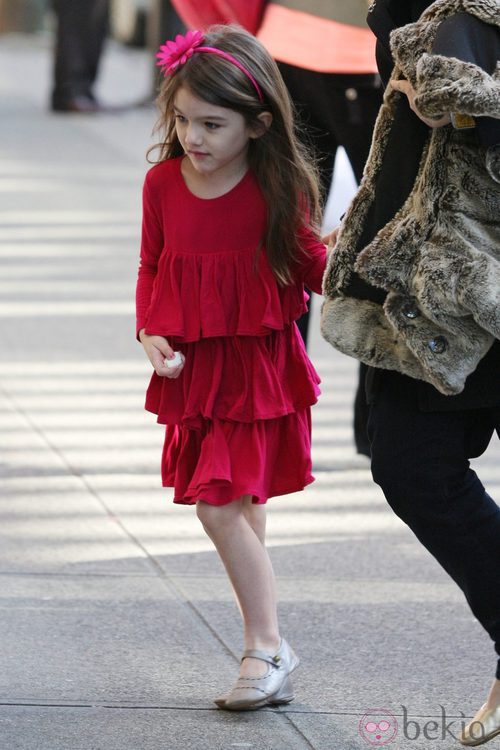 Suri Cruise con vestido de volantes y diadema con flor