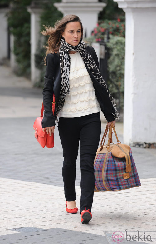Pippa Middleton con pantalón pitillo negro y bolso rojo