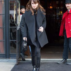 Dakota Johnson protegiéndose del frío con un look total black