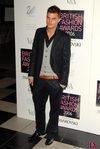Jamie Dornan con chaqueta negra y cardigan gris