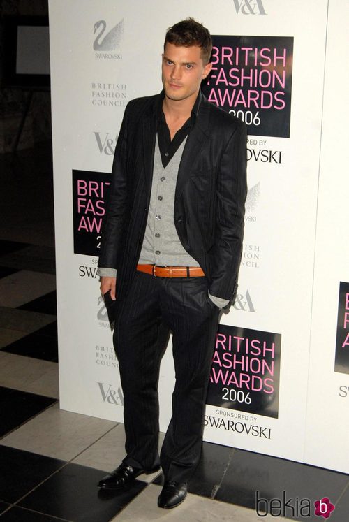 Jamie Dornan con chaqueta negra y cardigan gris