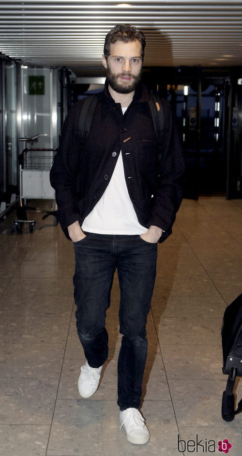 Jamie Dornan con chaqueta negra, camiseta blanca y vaqueros