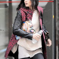 Clara Lago con jersey beige, leggings negros y abrigo con 'animal print' rojo
