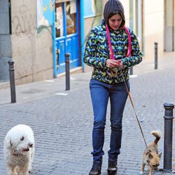 Adriana Ugarte con vaqueros y abrigo de colores paseando a sus perros