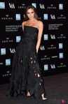 Victoria Beckham con un vestido negro con calado y escote palabra de honor