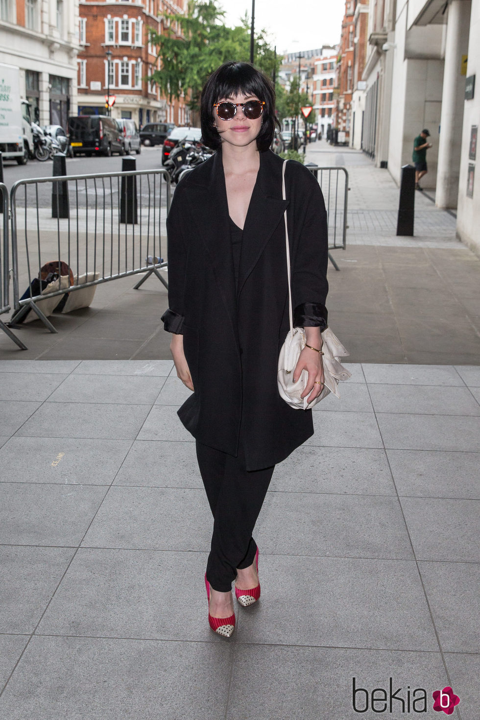 Carly Rae Jepsen con un look total black con zapatos de salón rojos con puntera de topitos