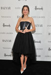 Marion Cotillard con vestido negro sujetando premio a la mujer del año de Harper