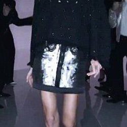 Modelo desfilando con un jersey negro y falda plateada en la nueva campaña del diseñador Tom Ford