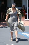 Kim Kardashian con vestido gris y gabardina en su segundo embarazo