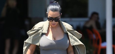 Kim Kardashian con vestido gris y gabardina en su segundo embarazo
