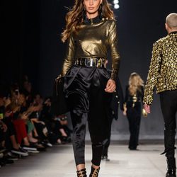 Joan Smalls con camisa dorada y pantalón negro en el desfile de Balmain para H&M en Nueva York