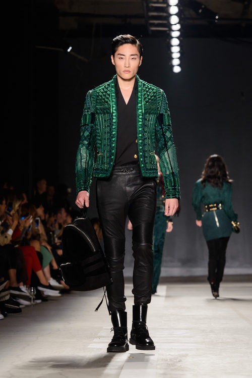 Modelo con chaqueta verde y pantalón negro en el desfile de Balmain para H&M en Nueva York