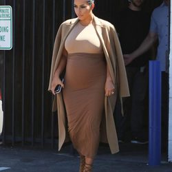 Kim Kardashian con vestido y abrigo en tonos tierra en su segundo embarazo