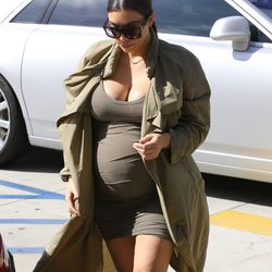 Kim Kardashian con mini vestido y gabardina caqui en su segundo embarazo