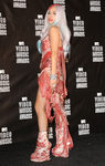 Lady Gaga con un look de carne cruda compuesto por vestido, tocado y botines de filetes