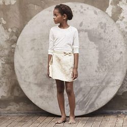 Camiseta blanca y falda beige con mensaje de  de la colección cápsula Kids Premium de IKKS