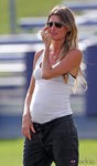 Gisele Bündchen con camiseta blanca de tirantes y pantalón gris oscuro
