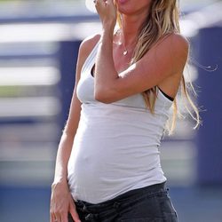 Gisele Bündchen con camiseta blanca de tirantes y pantalón gris oscuro
