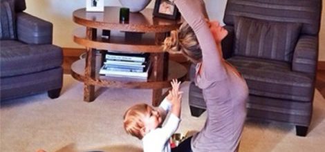 Gisele Bündchen con mallas azul marino y camiseta lila haciendo yoga con su hija Vivian
