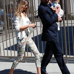 Gisele Bundchen con blazer blanca y pantalón floreado saliendo del bautizo de su hija Vivian con su marido