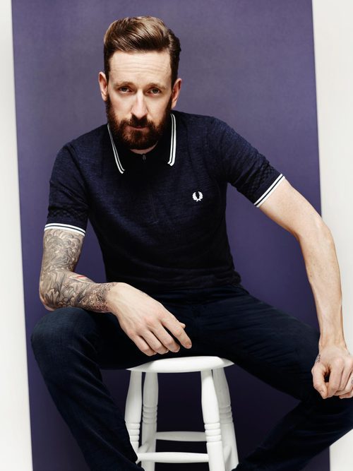 Bradley Wiggins con polo azul de su colección invierno 2016 para Fred Perry