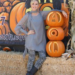 Heidi Klum con blusón y vaqueros junto a una calabaza gigante