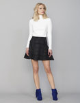 Jersey de cuello alto blanco y falda de cuadros grises y negros de la colección Tartán de Invierno 2015/2016 de Blanco