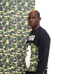 Mario balotelli con sudadera negra con logo y estampado camuflaje verde para la línea PUMA X BAPE