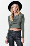 Modelo con top verde de manga larga y mandala con pantalones de cuero y sombrero de Kendall y Kylie Jenner para PacSun