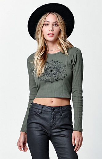 Modelo con top verde de manga larga y mandala con pantalones de cuero y sombrero de Kendall y Kylie Jenner para PacSun