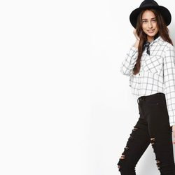 Modelo con blusa de cuadros y pantalones rotos con sombrero de Kendall y Kylie Jenner para PacSun