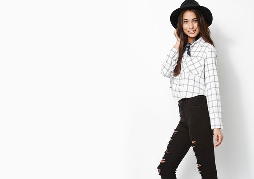 Modelo con blusa de cuadros y pantalones rotos con sombrero de Kendall y Kylie Jenner para PacSun